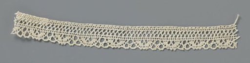 Strip of bobbin lace with a border of U-shaped motifs alternated by three round meshes