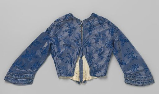 Bodice with long sleeves and blue-white passementerie, deep V-shaped neckline, button closure and pleated bodice with gathered front, of blue changeant taffeta with floral branches.
