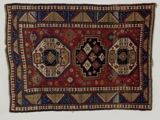 Carpet with three medallions filled with geometric figures on a red ground. Three borders; the middle one divided by diagonals into green and blue triangles.