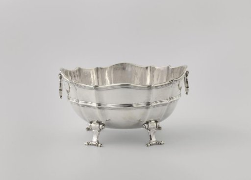 Silver sauce boat, oval, on four scrolled feet. Filigree borders along the carved top edge.