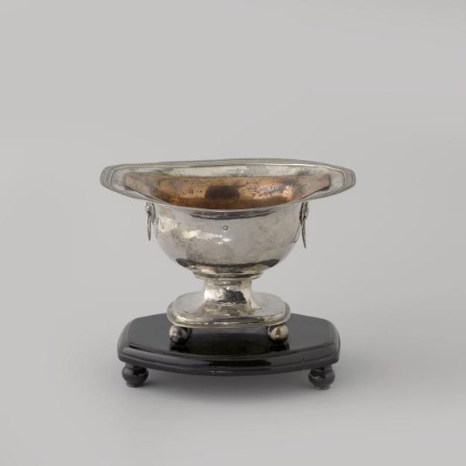 Silver pipe warmer on a wooden tray, oval with a horizontally flared rim. With a lion's head holding a ring on the sides.