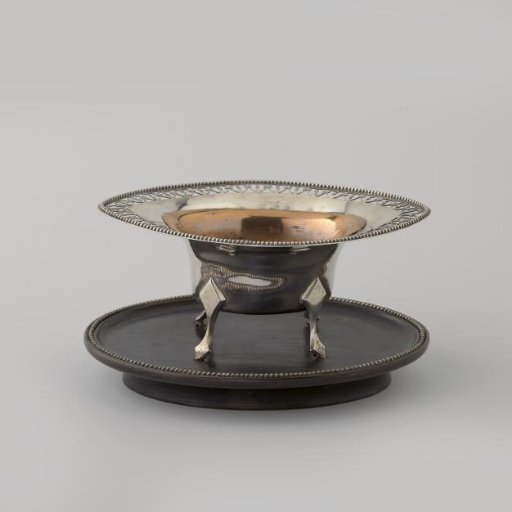 Stove of silver on four legs on a wooden top