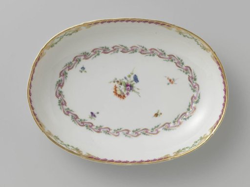 Bowl, deep and oval in shape, belonging to a service with a swirled ribbon motif with leafy branches, floral bouquets and scattered flower branches