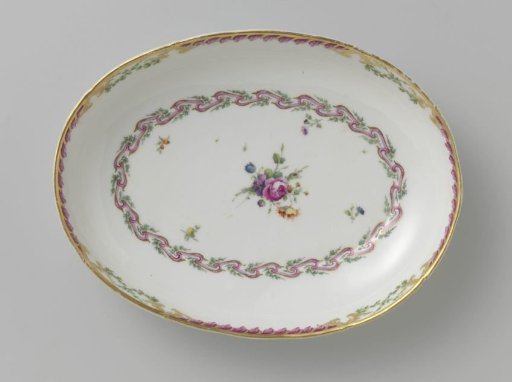 Bowl, deep and oval in shape, belonging to a service with a swirled ribbon motif with leafy branches, floral bouquets and scattered flower branches