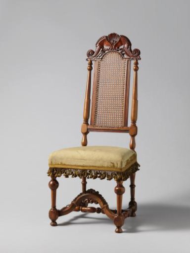 Walnut chair with a sculpted back in the middle decorated with carving