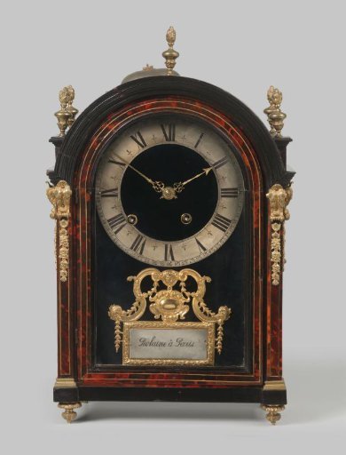 Table clock, veneered with tortoiseshell and black pearwood, and with gilded bronze frames. Crowned with five vases with flames