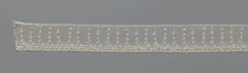 Strip of needle lace with rows of sprigs and arched lines