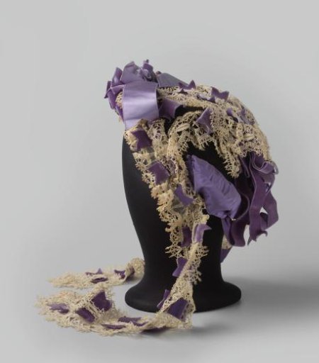 Bonnet-coiffure of lilac satin, silk ribbon, velvet band and lace sewn on a black tulle ground, semi-circular stiffened brim at the front and with hanging ribbons