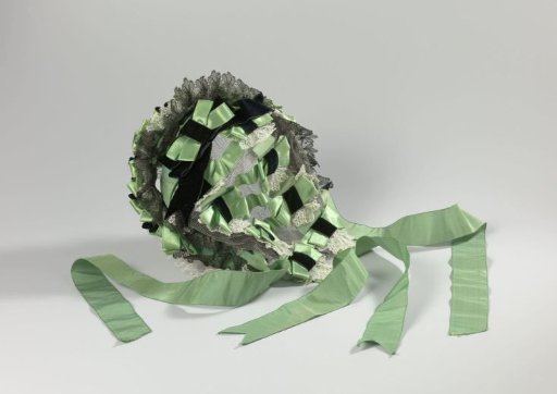 Bonnet-coiffure of green satin, silk ribbon, velvet band and lace sewn on a black tulle ground