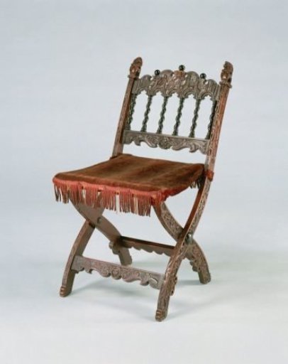 Church chair, folding, with upholstered seat. Back decorated with twisted Tuscan colonnettes and a top rail adorned with the Judgment of Solomon.