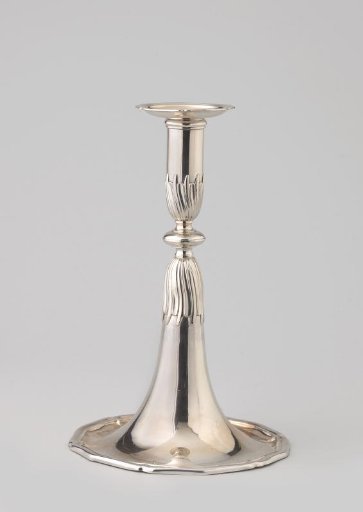 Candlestick with a round foot divided into six parts, gradually merging into the stem with a disc-shaped node.