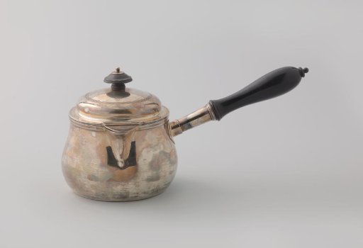 Silver pan. The round unadorned vessel with a long ebony handle is slightly widened at the bottom. With lid and hinged flap for the spout.