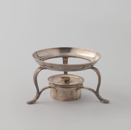 Silver stove on three curved and fluted legs.