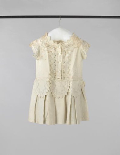 Children's dress of white cotton piqué, with passementerie, soutache and zigzag borders