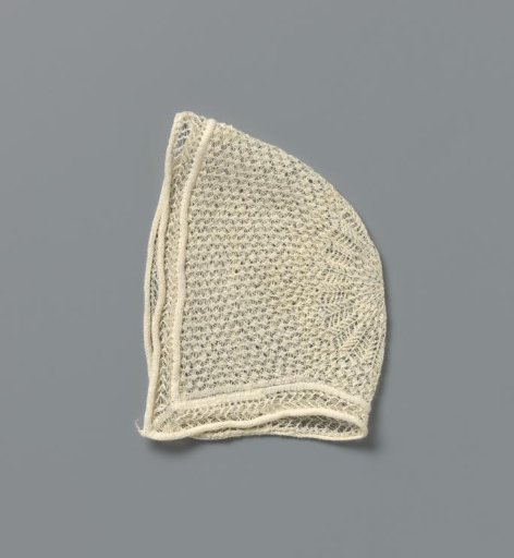 Cap of very fine knitted white cotton, star-shaped in the crown and outside scattered with florets; around zigzag lines between two thick ribbed edges