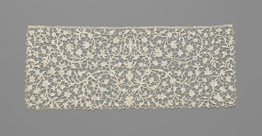 Slip of needle lace with a symmetrical pattern of thin curling vines with various flowers
