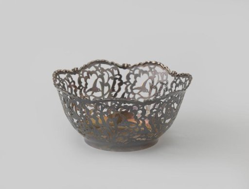 Basket of silver with vaulted, lobed wall, pierced with vines and birds