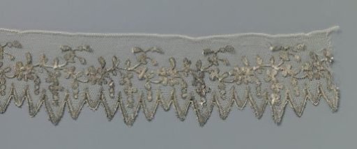 Strip of bobbin lace and silver lace with floral vine and hanging berries