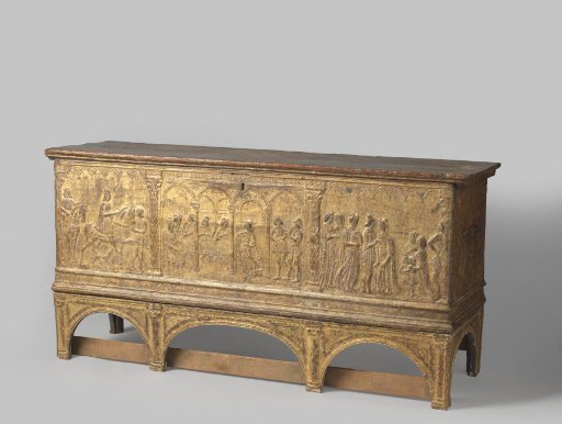 Chest of gilded poplar wood, front panel decorated with stucco reliefs and divided into three by two columns with scaly shafts, containing depictions related to the celebration of a festive meal with dance and music in a hall divided by arches