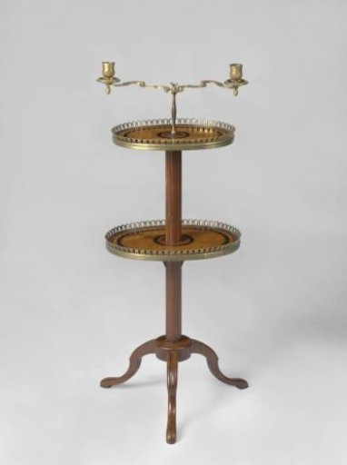 Table, decorated with marquetry and standing on three broken S-shaped, radially arranged feet, with a cylindrical crossbar and a grooved stem. With two oval tops with gilded bronze rims