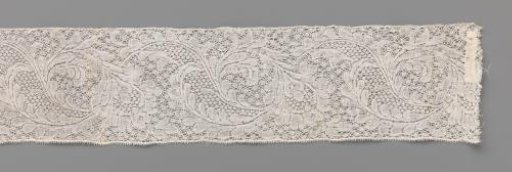 Strip of bobbin lace with an S-shaped cartouche and pear-shaped flower