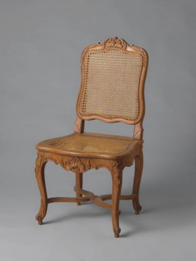 Chair of walnut and beech wood with S-shaped splayed legs; X-shaped cross with rosette; carved floral and foliate work, wicker back and seat, with loose cushion