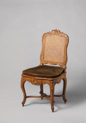 Chair of walnut and beech with S-shaped splayed legs; X-shaped stretcher with rosette; carved floral and foliate work, rush seat and back, with loose cushion