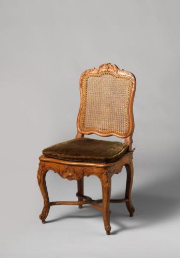 Chair of walnut and beech with S-shaped splayed legs; X-shaped stretcher with rosette; carved floral and foliate work, rush seat and back, with loose cushion