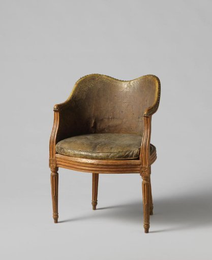 Armchair of beechwood with four fluted legs, a semicircular backrest frame and S-shaped curved fluted armrests, back and seat of cane, with a loose leather cushion