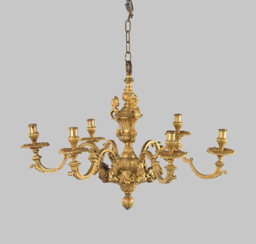 Crown of gilded bronze with six C-scroll arms with ram's heads. Stem with vase-shaped finial featuring four female busts whose lower bodies end in claws.