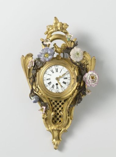 Notched clock of gilded bronze with a round dial decorated with rocailles and metal-painted leafy branches with porcelain flowers