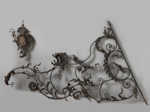 Hanging arm, decorated with scrolls ending in bird heads. Coll. Mannheimer.