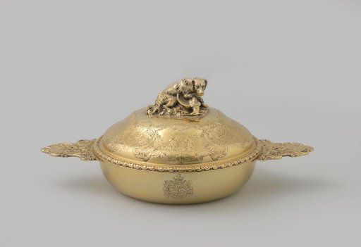 Covered dish of gilt silver, flat, with lid and two horizontal handles decorated with hunting gear, on the lid among others a dog with a dead snipe