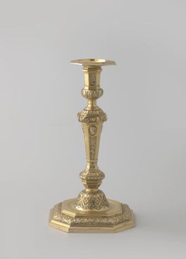 Candelabrum, part of a pair, of gilt silver. Decorated on the stem with trophies and musical instruments above which profile heads in medallions