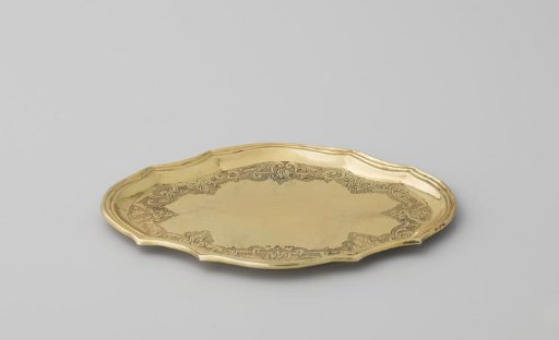 Underplate of gilded silver, oval, with scalloped edge and decorated with strapwork. With accompanying terrine