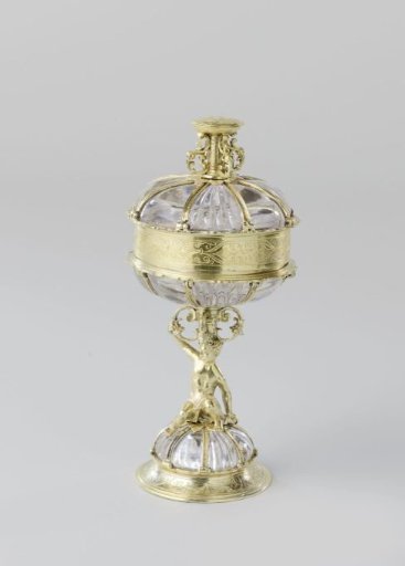 Covered beaker of rock crystal with a mount of gilded silver. On a dome-shaped foot, a naked youth holds the mount of the vessel with one hand.