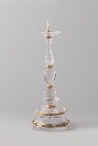 Candelabrum with candle socket and drip pan of rock crystal in a mount of gold and gilded silver with enamel. The foot is decorated with garlands and bunches of fruit in cut work.