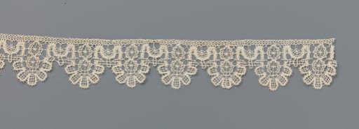 Strip of bobbin lace with wheels and five-lobed shells