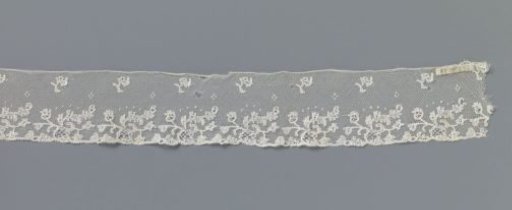 Strip of bobbin lace with a branch lying above an openwork oval