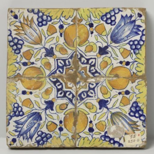 Field of four tiles (2x2) with a multicoloured pattern in blue, yellow, orange and purple of pomegranates, grape clusters and tulips around a star