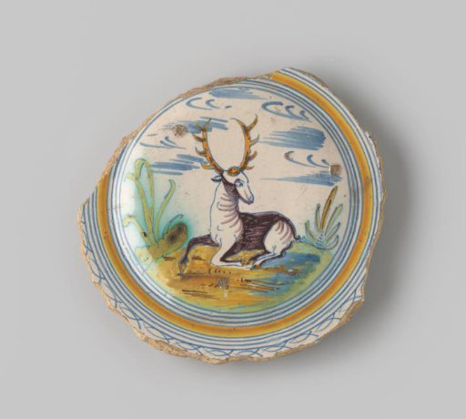 Fragment of a plate with a reclining stag on a grassy ground with plants on the welling light