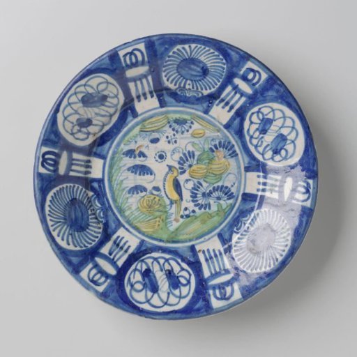 Dish, polychrome painted with a bird in a landscape with flowers and leaves on the flat surface. Rim with panels containing stylized flowers.