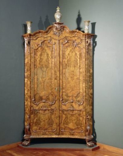 Corner cabinet with two doors, veneered with burr walnut, with a curved pediment, angularly curved cornice, and pierced crest with rocaille