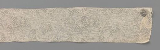 Strip of bobbin lace with long feathered and curling leaves