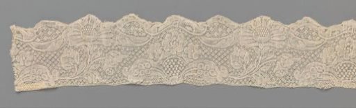 Strip of bobbin lace with a cartouche from which a daisy springs, forming a shell along the lower edge