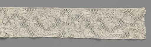 Strip of bobbin lace with wavy vine and curling flowers