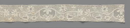 Strip of bobbin lace with flower pot in kidney-shaped medallion