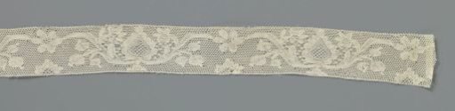 Strip of bobbin lace with a pot or bowl with a pine cone