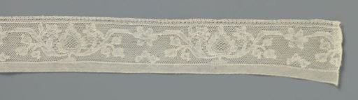 Strip of bobbin lace with a pot or bowl with a pine cone