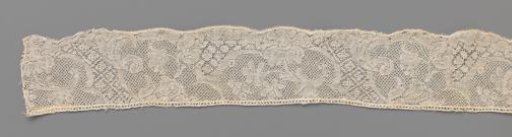Strip of bobbin lace with decorative bands and hanging carnation